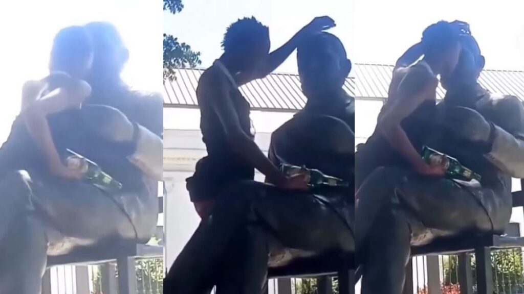con-botella-en-mano,-hombre-se-monta-y-acaricia-estatua-de-duarte